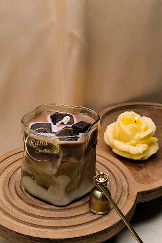 شمع دستساز لیوانی با فرم دفرمه، شبیه نوشیدنی آیسلته؛ ترکیب رنگ کرمی و قهوهای با بافت طبیعی و مدرن