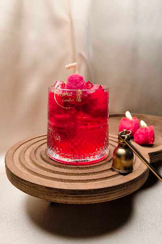 شمع لیوانی شربت توتفرنگی روی میز