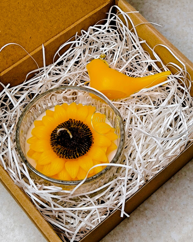 مجموعه شمع دو عددی شامل شات شیشهای با گل آفتابگردان و شمع با پرنده زرد، مناسب دکوراسیون منزل، هدیه زیبا و فضای گرم و دلنشین